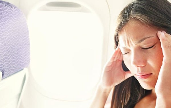 woman with travel pain on an airplane