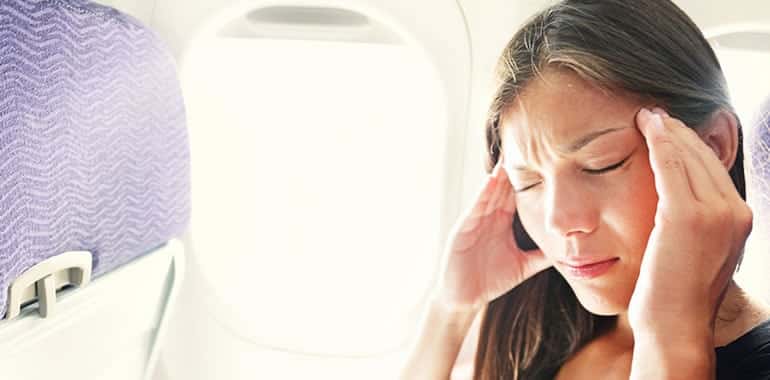 woman with travel pain on an airplane