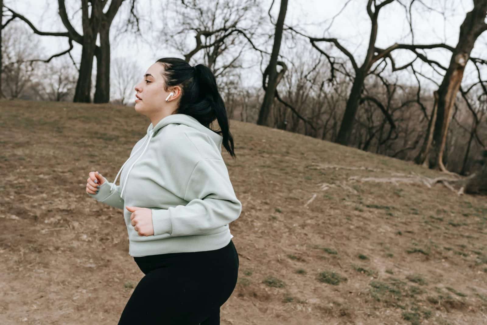 sportswoman jogging in autumn park