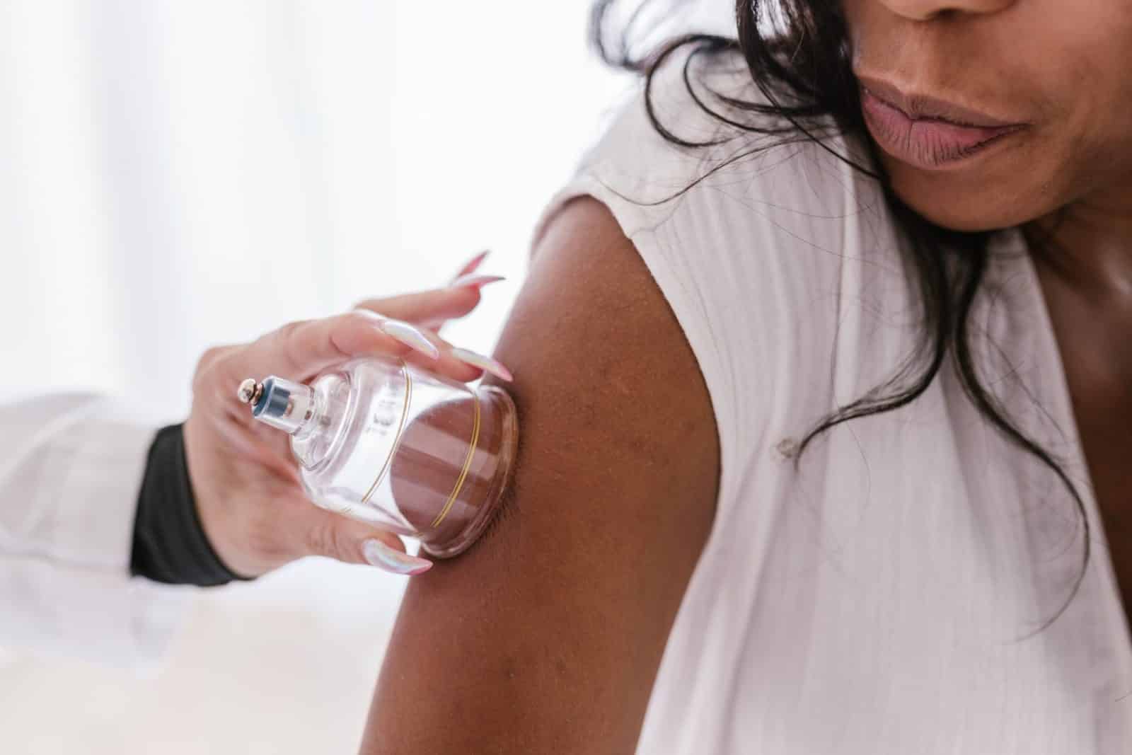 A Person Sticking Clear Glass Cup on a Woman's Arm