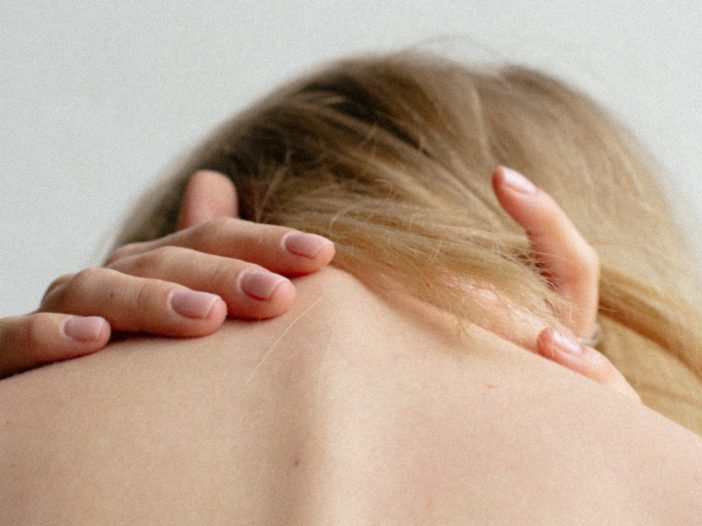 close up of woman clutching her spine