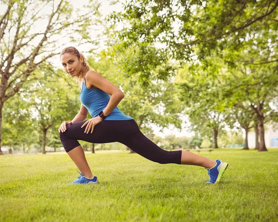 female runner stretching her hamstrings in a park