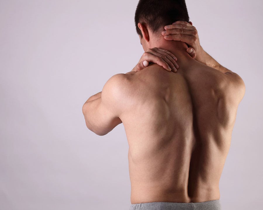 man clutching the back of his neck