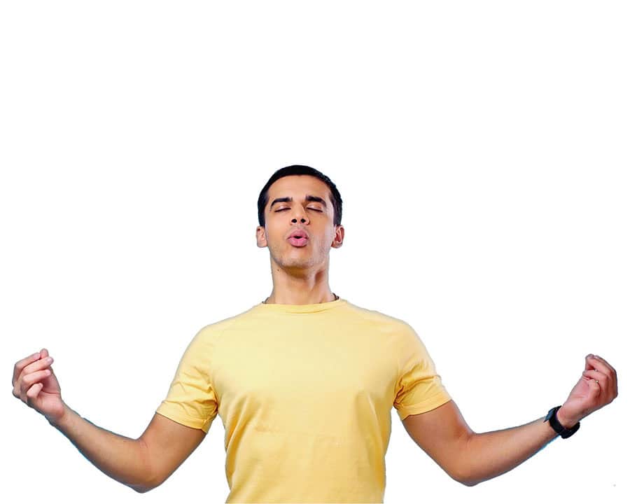 man in yellow t-shirt doing breathwork, with his arms extended out