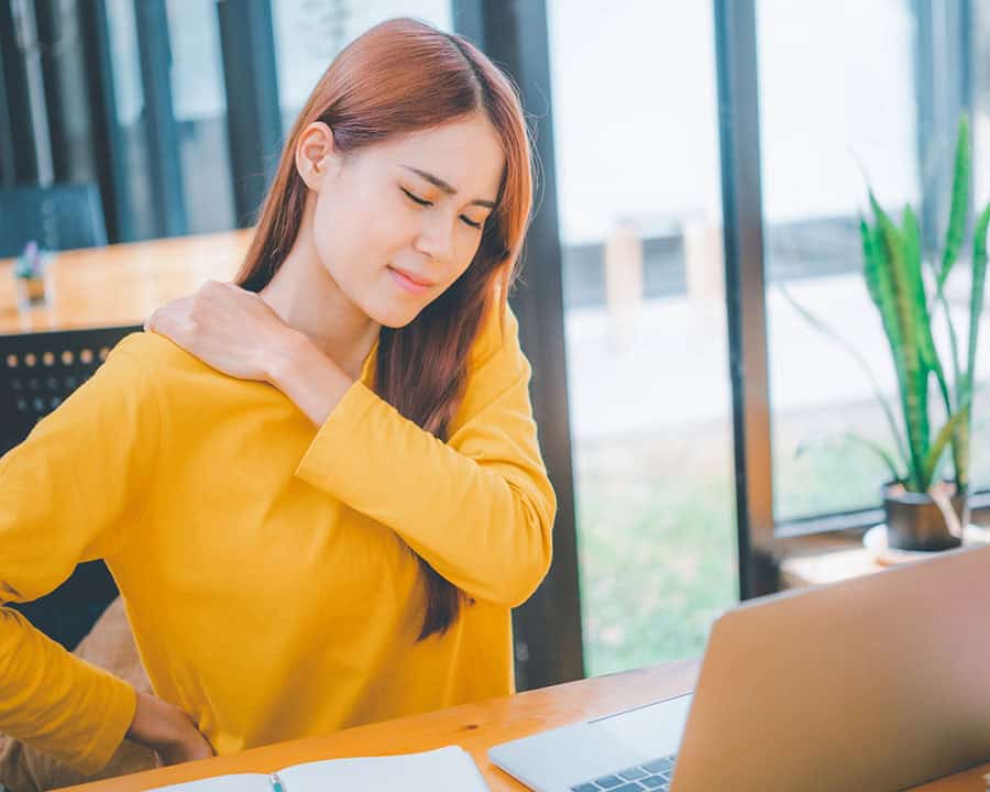 Female student studying online feel aches and pains while sitting online for long periods of time.