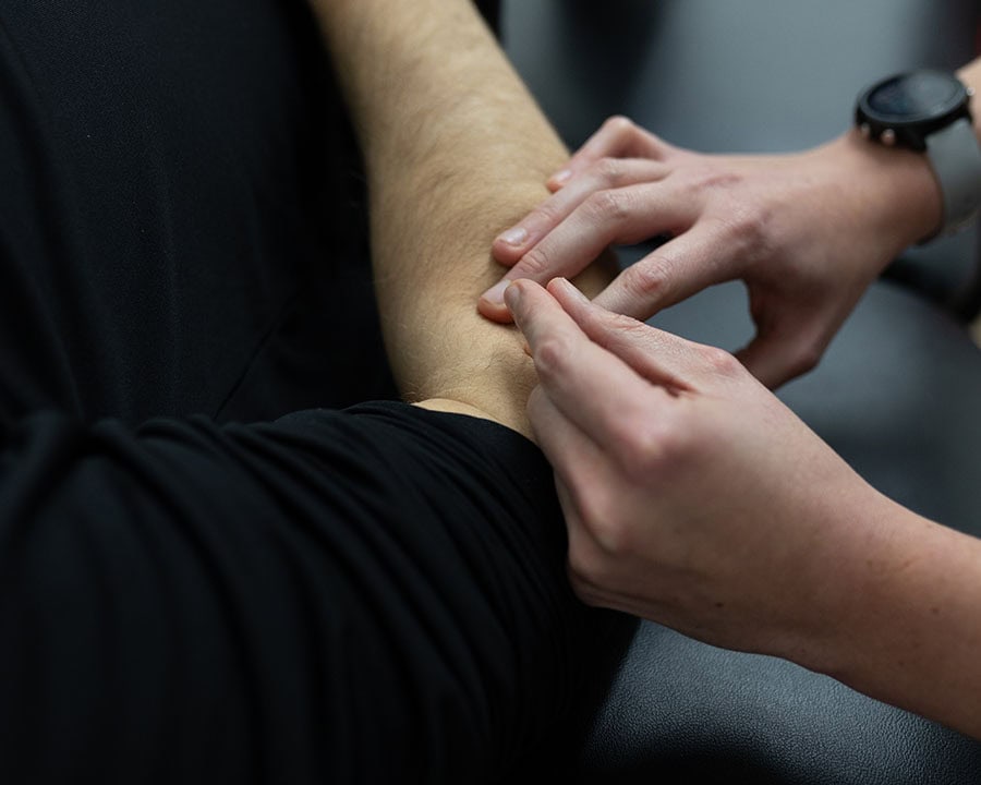 shockwave-treatment-knee physical therapist performing dry needling on elbow